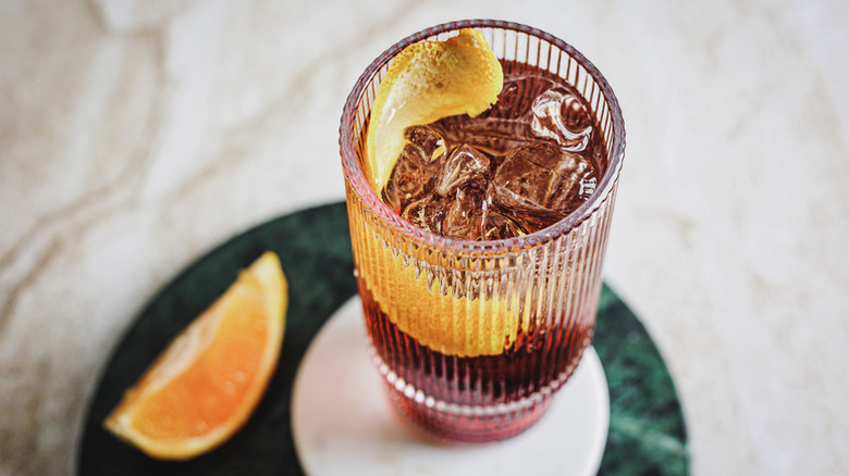 Americano cocktail in glass with ice and orange peel slice