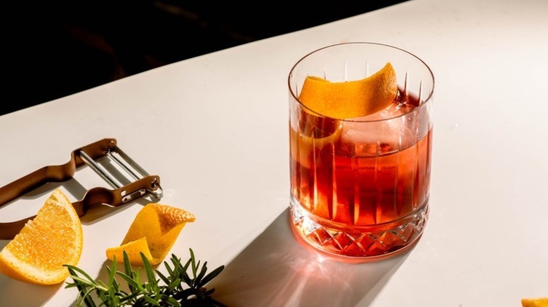 Negroni cocktail in glass with ice and orange peel twist