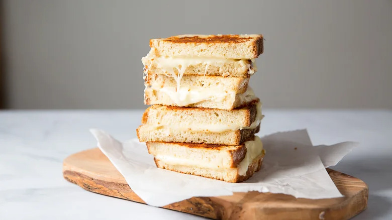 Copycat Starbucks Grilled Cheese sliced and stacked on parchment paper and a wooden cutting board