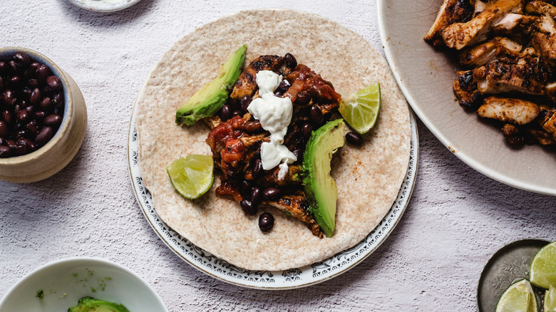 Tortilla with chipotle honey chicken with avocado, sour cream, lime and black beans