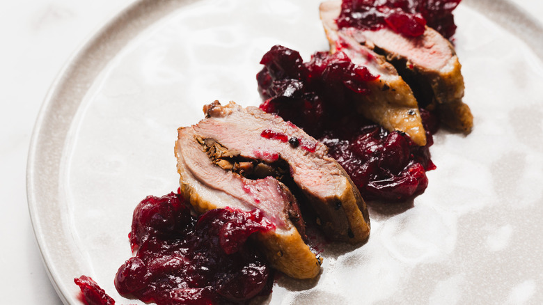 Sliced stuffed duck breasts with sauce on a plate