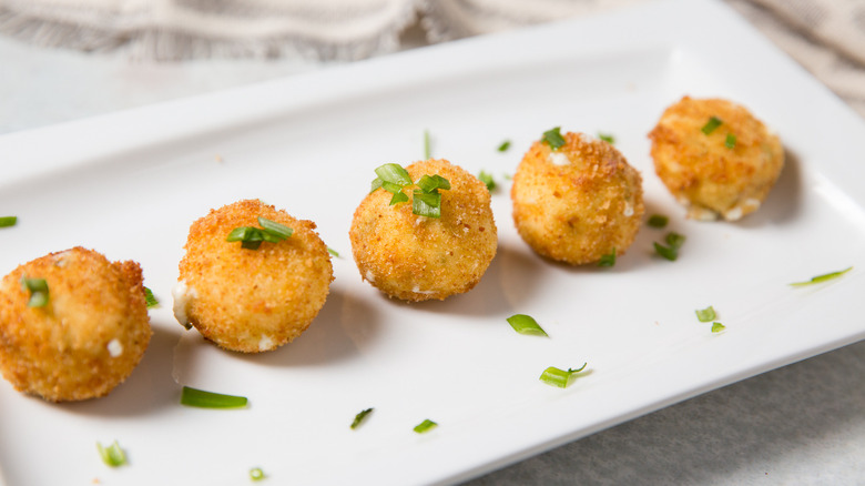 Goat cheese bites on serving dish garnished with chives
