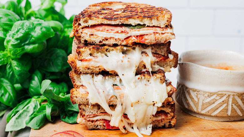 Four stacked pizza grilled cheese halves on cutting board