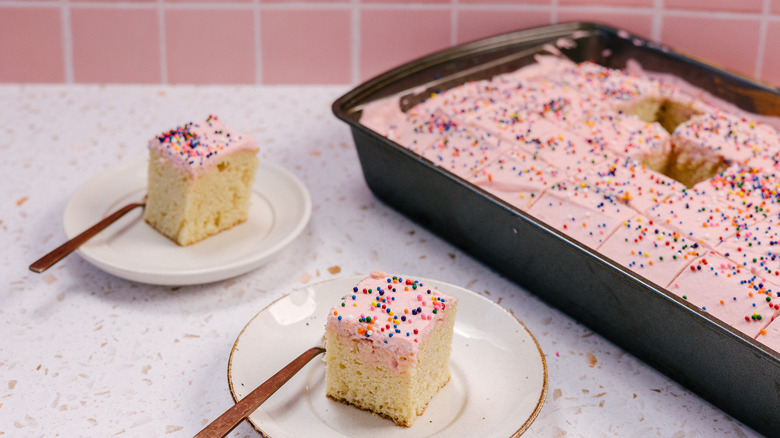 two slices of Mexican pink cake on small plates with large cake pan in background