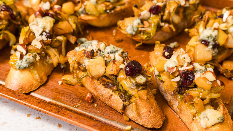 Slices of bruschetta with Brussels sprouts, pears and gorgonzola cheese on a baking sheet