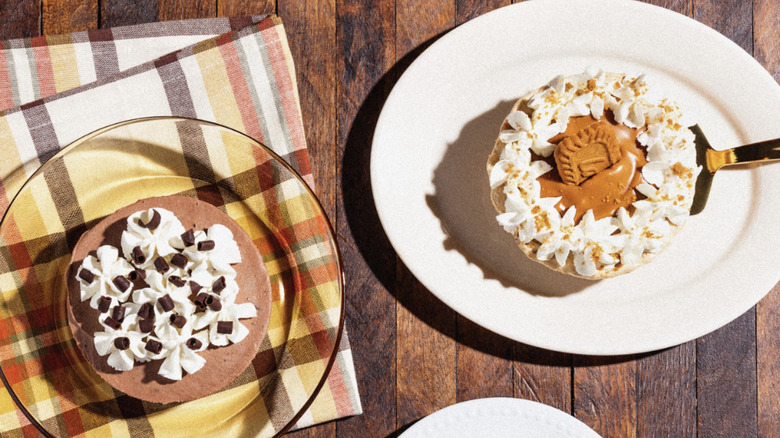 Two of Crumbl's mini pies, French Silk and Biscoff, on a wooden table