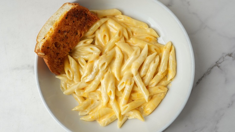 Overview of plated penne mac and cheese with bread