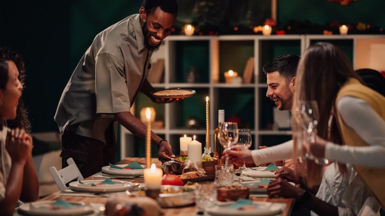 friends gathered at dinner table with candles