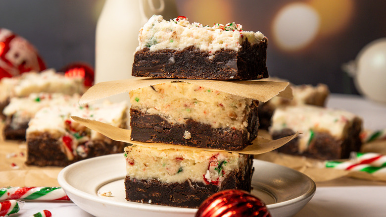 A stack of peppermint bark cookie bars with milk in background