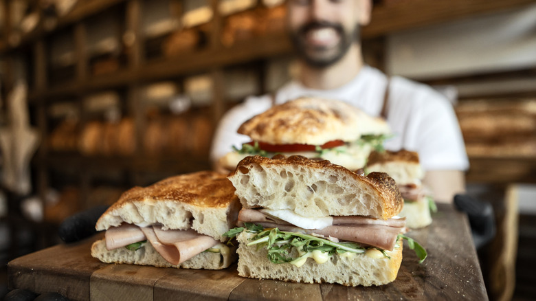 sandwich shop with employee showcasing subs