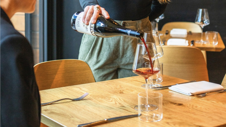 table at Tavernetta with wine being poured for customer