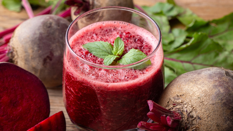a cup of beet juice with whole beets