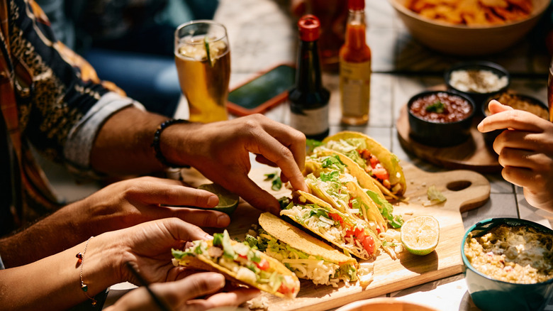 Tacos at a mexican restaurant with beer and food on table