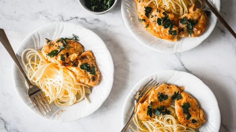 One-Skillet Creamy Chicken Lazone on white plates with pasta