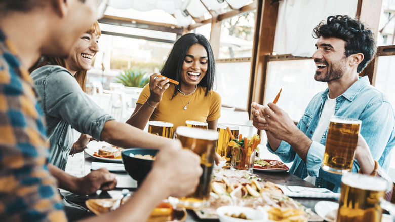 People eating, drinking beer at table