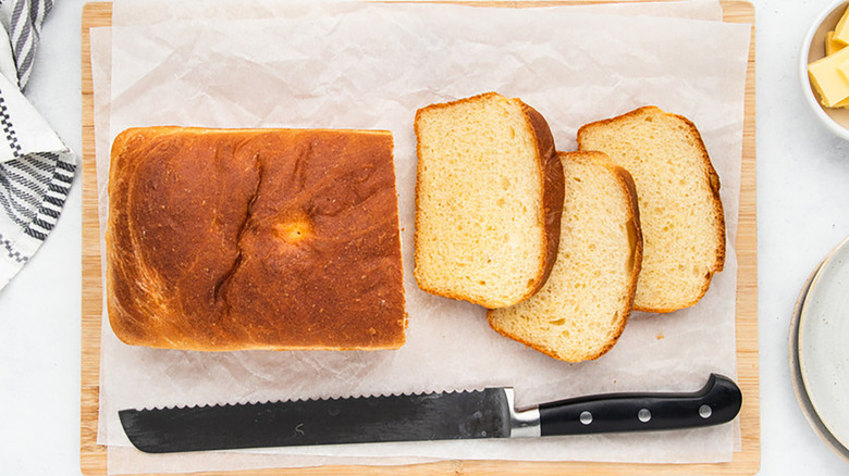 Sliced loaf of fluffy potato bread on a parchment-lined board