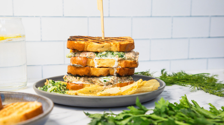 Two grilled salmon salad sandwiches one on top of the other.