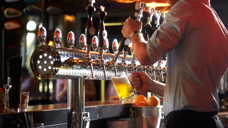 person tapping beer in a pub