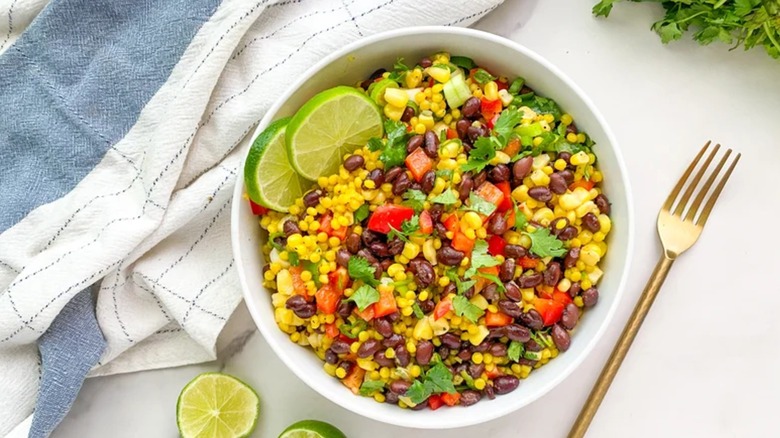 Limey Black Bean Couscous Salad in white bowl next to fork