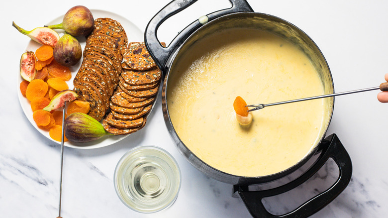 Dipping dried apricots into bleu cheese and honey fondue.