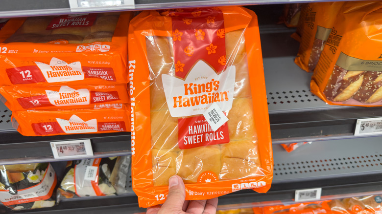 Hand holding package of King's Hawaiian rolls at store
