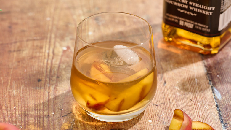 grilled peach old fashioned in a glass on a table
