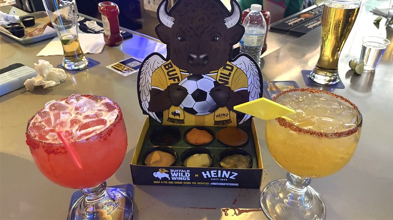 Red Card Punch and Yellow Card Margarita on either side of a Buffalo Wild Wings sauce bundle
