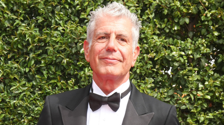Anthony Bourdain wearing a tux while walking a red carpet