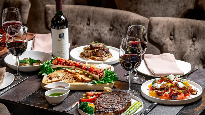 steakhouse table with steak dinner and wine