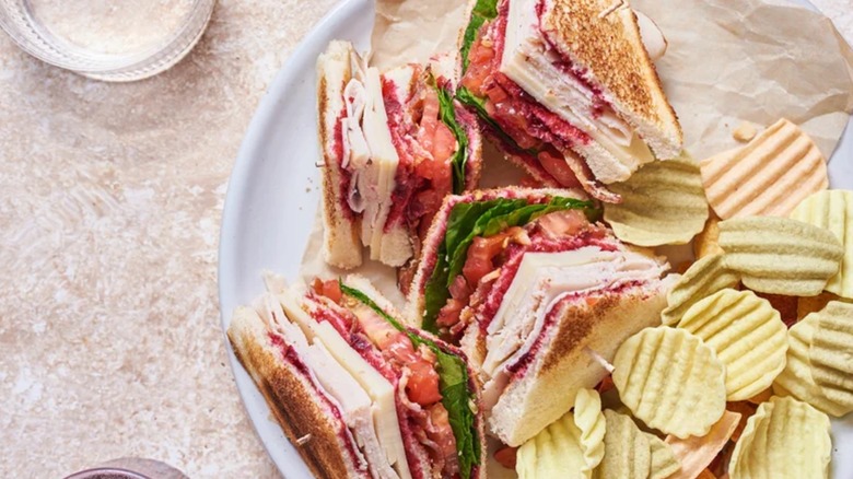 Sweet and Savory Club Sandwich with chips on plate