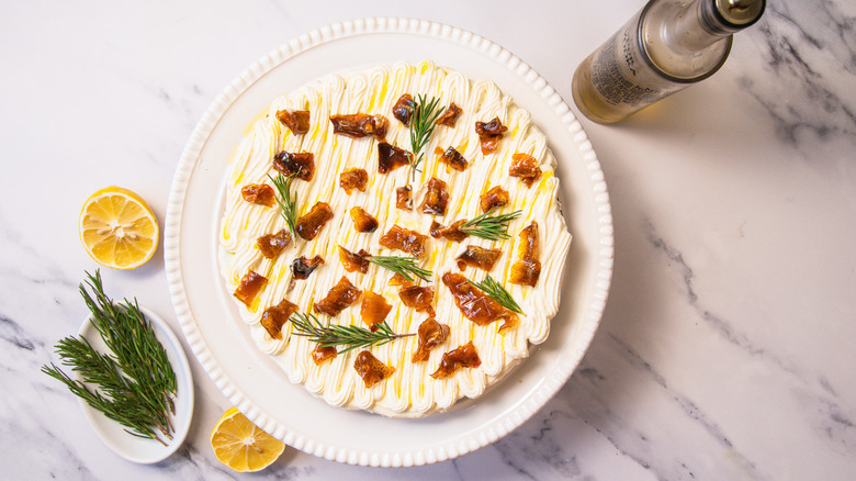 Gluten-free lemon olive oil cake with rosemary, lemon and olive oil around it