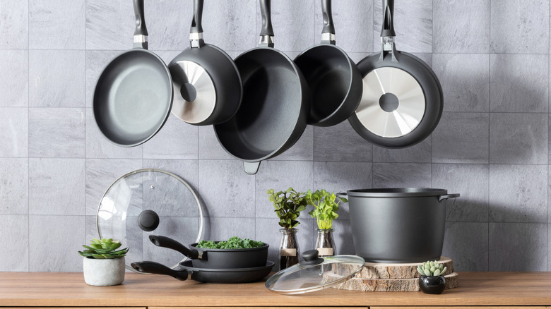 Variety of hanging cookware and cookware on counter in kitchen.