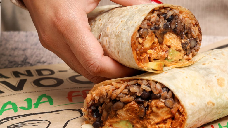 Someone holding half of a burrito from Baja Fresh Mexican Grill