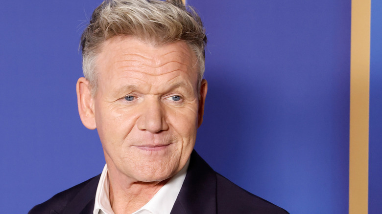 Gordon Ramsay smiling before blue background