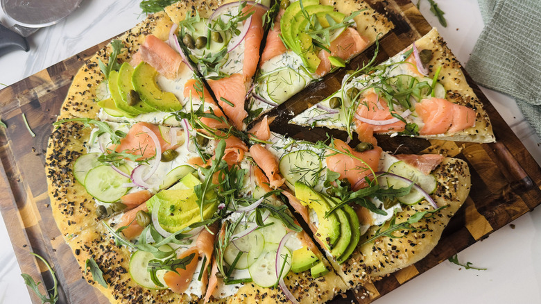 Bagels and lox inspired pizza on wooden board