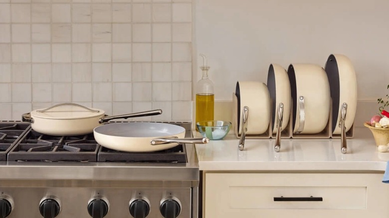 Caraway cookware pieces in cream on a stovetop and countertop.