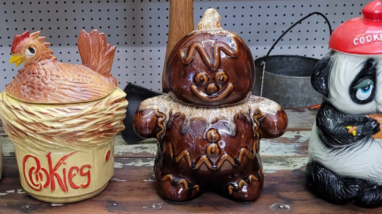 Various vintage cookie jars on a thrift store shelf.