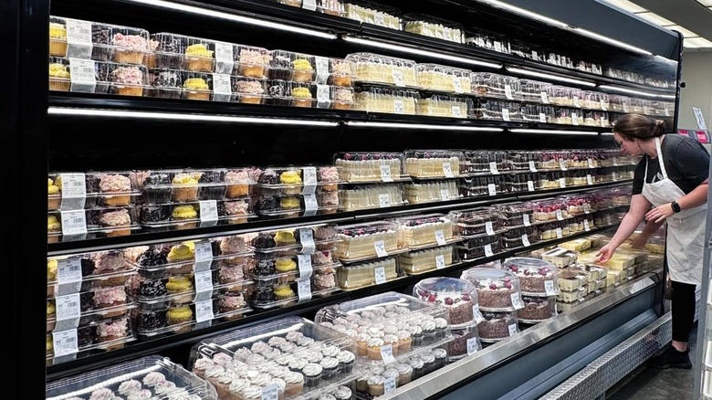 Baker placing items in the refrigerated case at the Sam's Club bakery