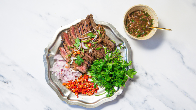 Thai-style grilled steak with all the accompaniments and sauce.