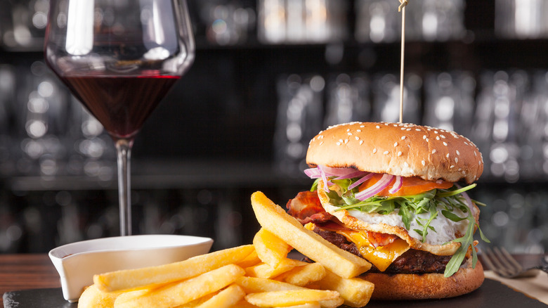 burger with fries and red wine glass