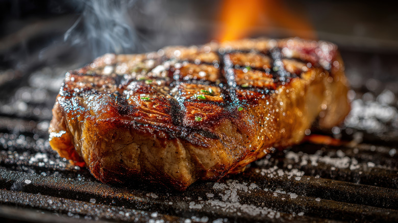 Beef steak sizzling on hot grill