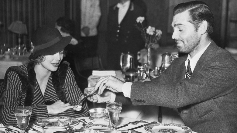 Black-and-white photo of Clark Gable and Loretta Young at restaurant table
