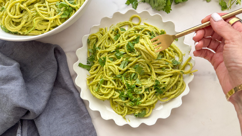 fork in dish of green spaghetti