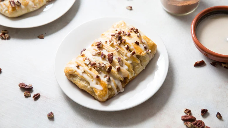 Elevated Panera Bread Pecan Braid with a creamy drizzle and chopped pecans
