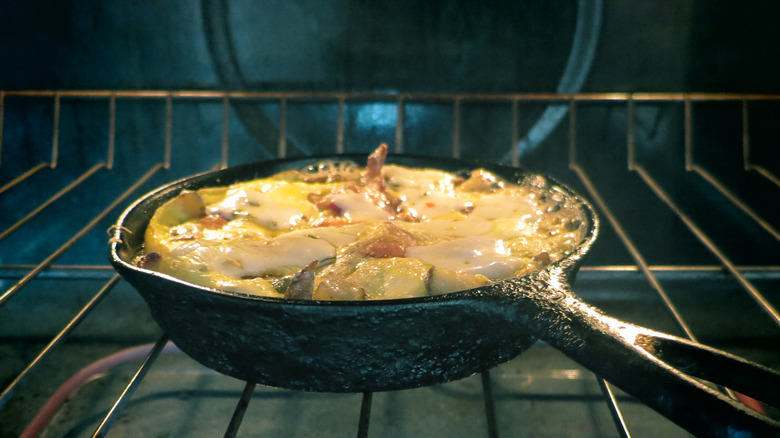 A cast iron skillet in an oven cooking a fritatta
