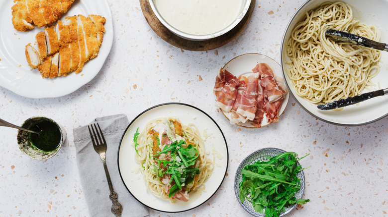 Chicken dish on white plate with ingredients all around