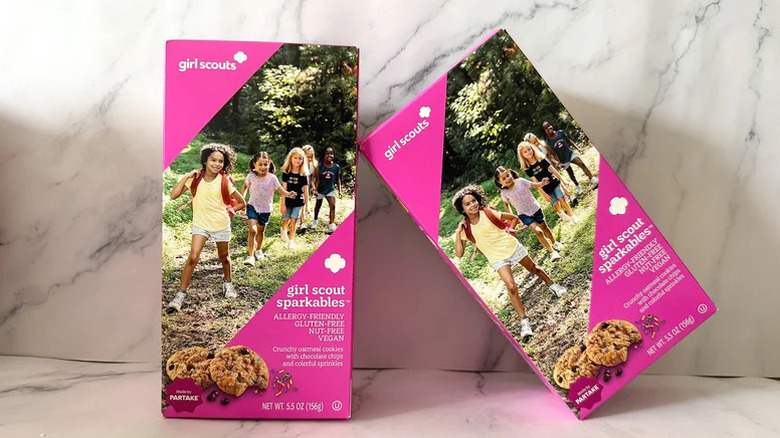 Boxes of Girl Scout Sparkables cookies on marble background