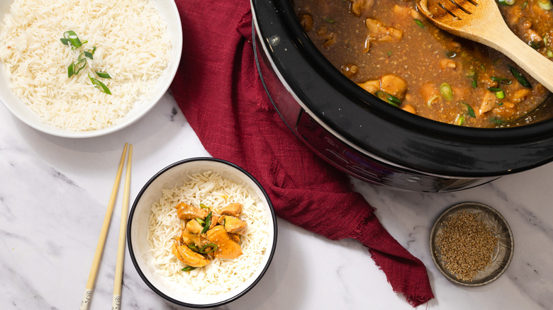 Orange chicken in slow cooker, in bowl with rice and besides another bowl of rice
