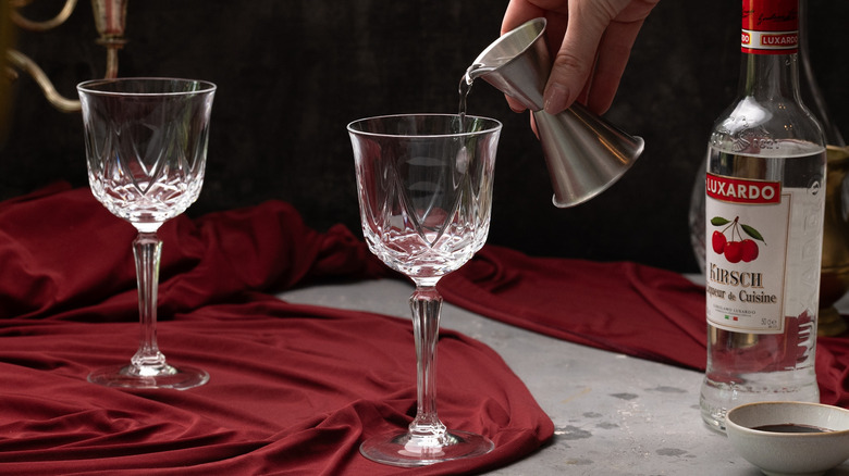 pouring kirsch into a glass