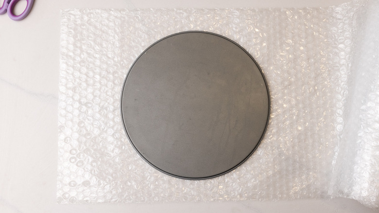 bubble wrap under cake pan base next to scissors